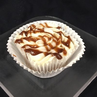 An apple butter cupcake with an apple butter filling, topped with cream cheese icing and finished with an apple butter apple cider drizzle. Apple Butter cupcake