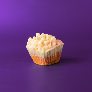 A strawberry cupcake with a white ganache filling, cream cheese icing, strawberry ganache drizzle, and topped with white morsels. White Chocolate Strawberry cupcake