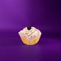 A vanilla cupcake with blackberry filling, topped with blackberry cream cheese icing and finished with a blackberry candy piece. Blackberry cupcake