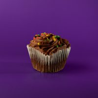 A chocolate cupcake with chocolate buttercream and seasonal sprinkles. Chocolate Chocolate cupcake