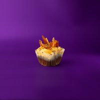 A dark chocolate bacon cupcake topped with caramel buttercream and finished with bacon pieces and a chocolate ganache drizzle. Dark Chocolate Bacon cupcake