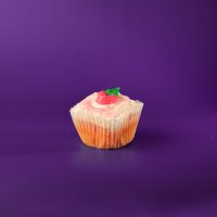 A strawberry cupcake with strawberry cream cheese icing, a buttercream strawberry, and pink sanding sugar. Strawberry cupcake