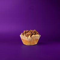An oatmeal chocolate chip bacon cupcake, filled with chocolate ganache filling, topped with peanut butter buttercream, and finished with a chocolate ganache drizzle and no-bake chocolate oatmeal bacon cookie crumble. Bacon Trail Mix cupcake