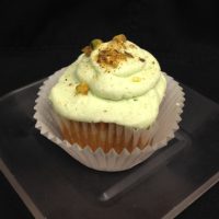 A pistachio cupcake filled with pistachio pudding, topped with pistachio cream cheese icing and finished with crushed pistachios. Pistachio cupcake