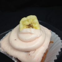 A strawberry cupcake, filled with banana pudding, topped with strawberry cream cheese icing and finished with a banana chip. Straw-Nana cupcake