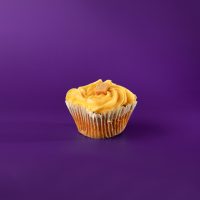 A caramel cupcake with caramel filling topped with caramel buttercream, caramel drizzle, sea salt, and a piece of caramel candy. Salted Caramel cupcake