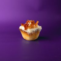 A bacon poundcake cupcake topped with cream cheese icing and bacon pieces. Bacon Pound cupcake