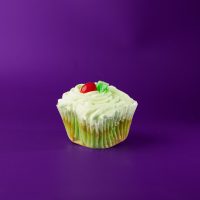 A lime cupcake with cherries filled with a non-dairy cherry filling, topped with lime buttercream and finished with 1/2 of a cherry and a piece of lime candy. Cherry Limeade cupcake