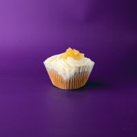 A spice cupcake filled with apple pie filling, topped with cream cheese icing, and finished with a dollop of apple pie filling. Apple Spice cupcake