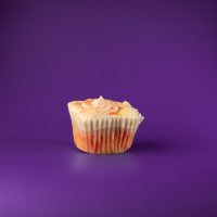 A strawberry cupcake with lemon curd filling, topped with strawberry cream cheese icing and finished with a dusting of crushed lemon heads and dried strawberries. Strawberry Lemonade cupcake