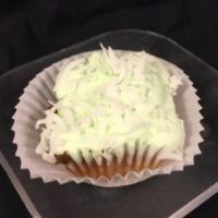 A coconut cupcake with a coconut/lime pudding filling, topped with lime buttercream then sprinkled with coconut flakes. Lime in the Coconut cupcake