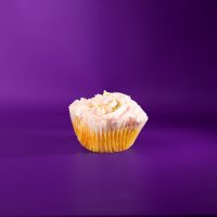 A vanilla cupcake with a fudge filling, topped with pink buttercream and nonpareils. Sugar Rush cupcake