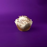 A chocolate cupcake with a white ganache filling, topped with vanilla buttercream and finished with a chocolate ganache drizzle. Black Tie cupcake
