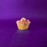 A white chocolate raspberry cupcake topped with raspberry cream cheese icing and finished with a raspberry jam drizzle and white morsels. White Chocolate Raspberry cupcake