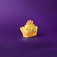 A banana cupcake with banana buttercream, filled and drizzled with chocolate ganache and topped with a banana chip. Chocolate Monkey cupcake