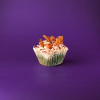 A blueberry maple bacon cupcake, filled with a blueberry bacon mixture, frosted with maple buttercream then topped with bacon pieces and blueberry drizzle. Blueberry Maple Bacon cupcake