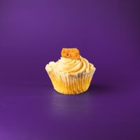 A banana cupcake with banana filling and brown sugar cream cheese icing, with a candied banana piece on top. Brown Sugar Banana cupcake