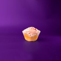A cherry chip cupcake topped with cherry cream cheese icing and finished with red sanding sugar. Cherry Chip cupcake