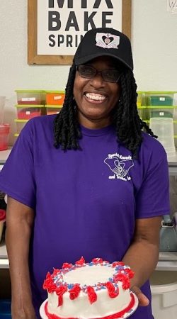 Darlene A staff member holding her decorated cake